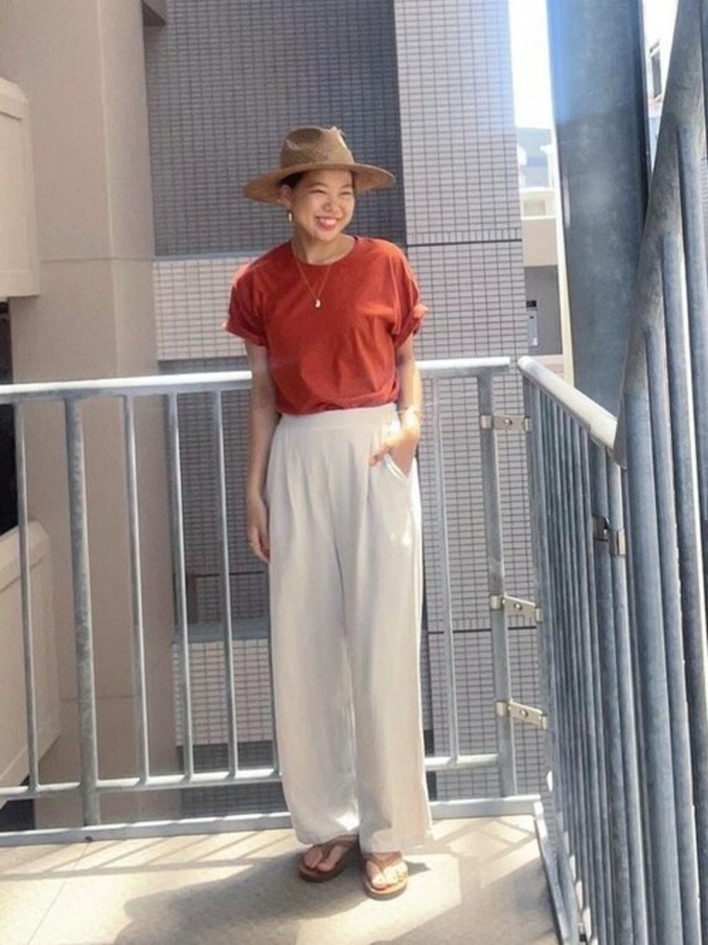 ベージュ系のデニムパンツ、オレンジ系のTシャツ/カットソーを着用したレディースの夏コーディネートの1枚目の写真