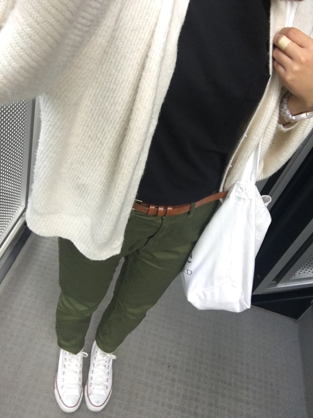 ホワイト系のニット/セーター、ブラック系のTシャツ/カットソー、グリーン系のその他パンツを着用したレディースの秋コーディネートの1枚目の写真