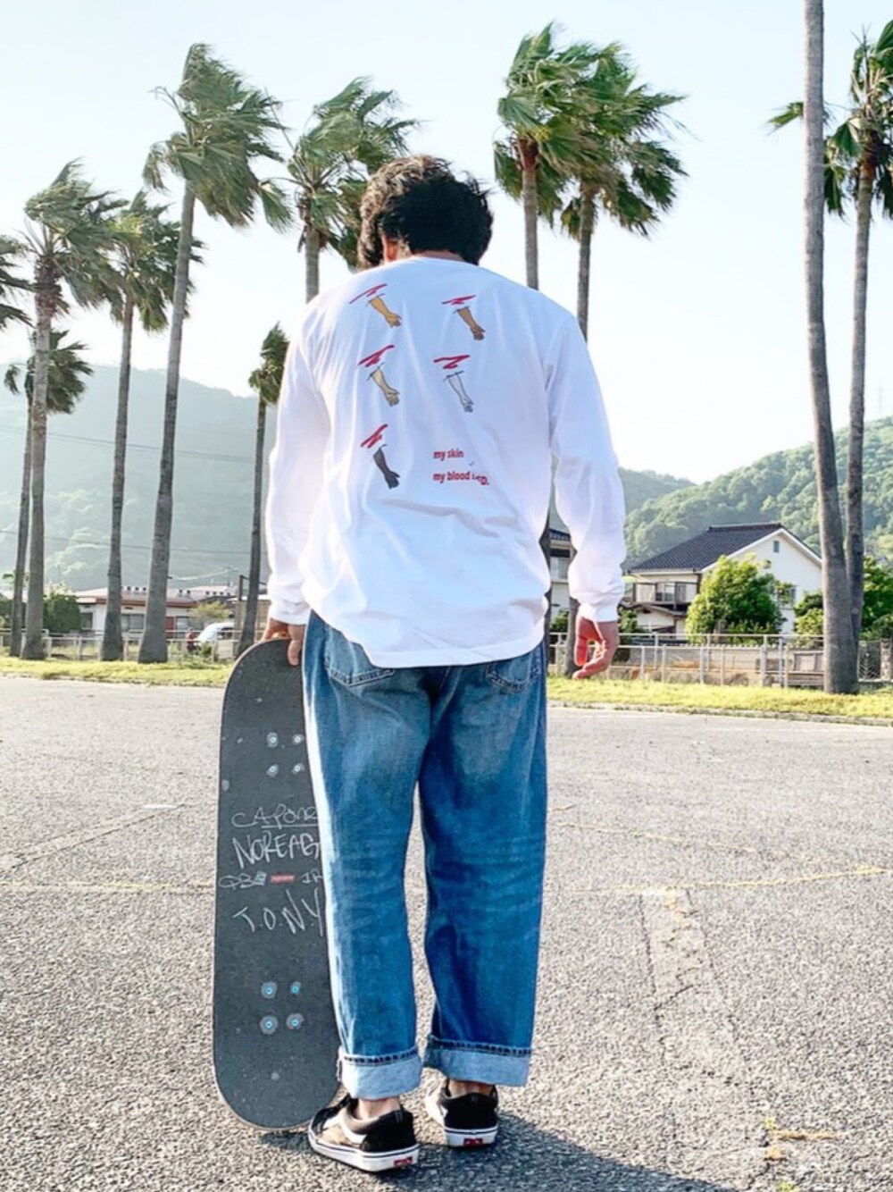 ホワイト系のTシャツ/カットソー、ブラック系のスニーカー、ブルー系のデニムパンツを着用したメンズの春コーディネートの1枚目の写真