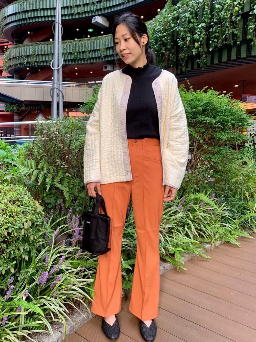 ブラック系のサンダル、オレンジ系のスラックス、ブラック系のトートバッグを着用したレディースの秋コーディネートの1枚目の写真