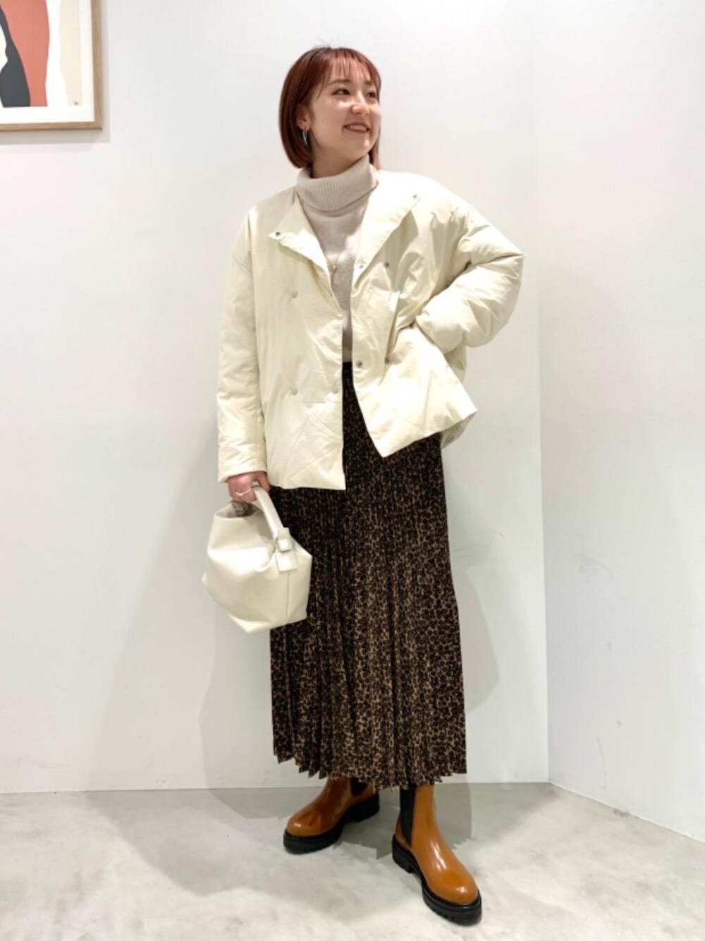 ベージュ系のニット/セーター、ベージュ系のダウンジャケット/コート、ブラウン系のブーツを着用したレディースの冬コーディネートの1枚目の写真