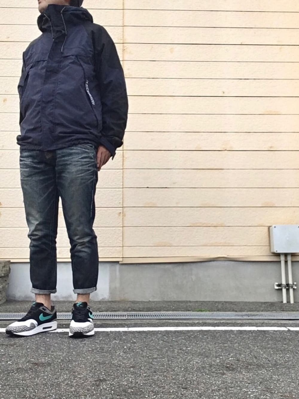 ブルー系のパンツ、ブラック系のスニーカー、ブルー系のマウンテンパーカーを着用したメンズの秋コーディネートの1枚目の写真