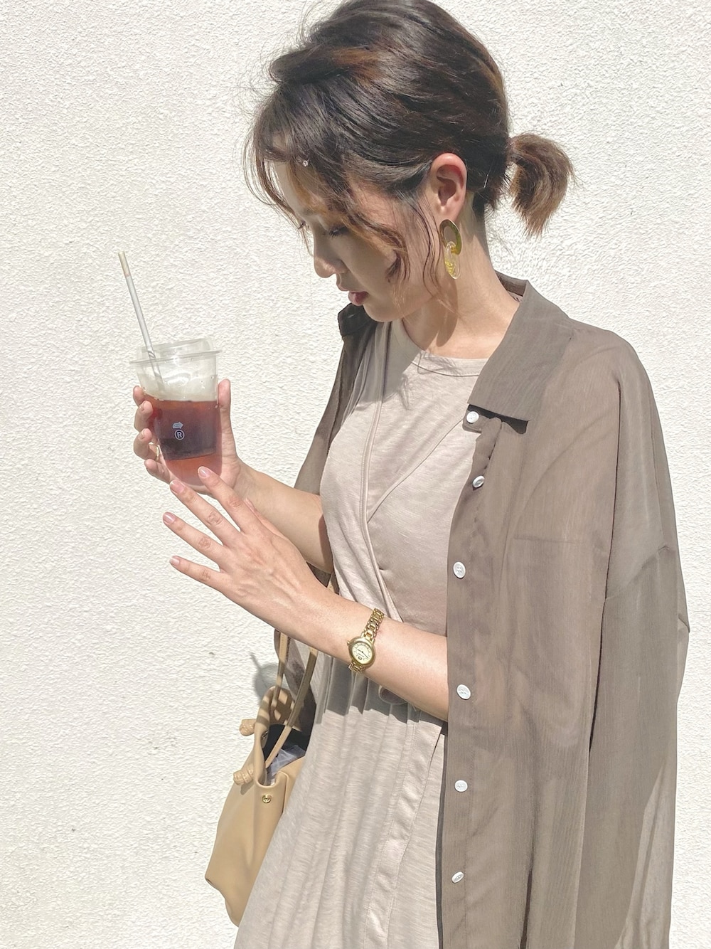 ベージュ系のワンピース、ブラウン系のシャツ/ブラウス、ゴールド系のピアス(両耳用)を着用したレディースの夏コーディネートの1枚目の写真