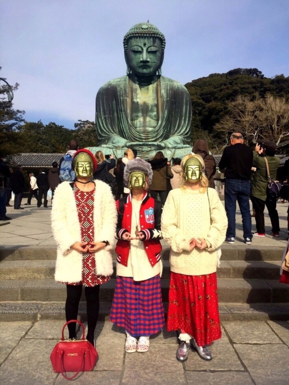 レッド系のスタジャン、ホワイト系のニット/セーター、レッド系のスカートを着用したレディースの冬コーディネートの1枚目の写真