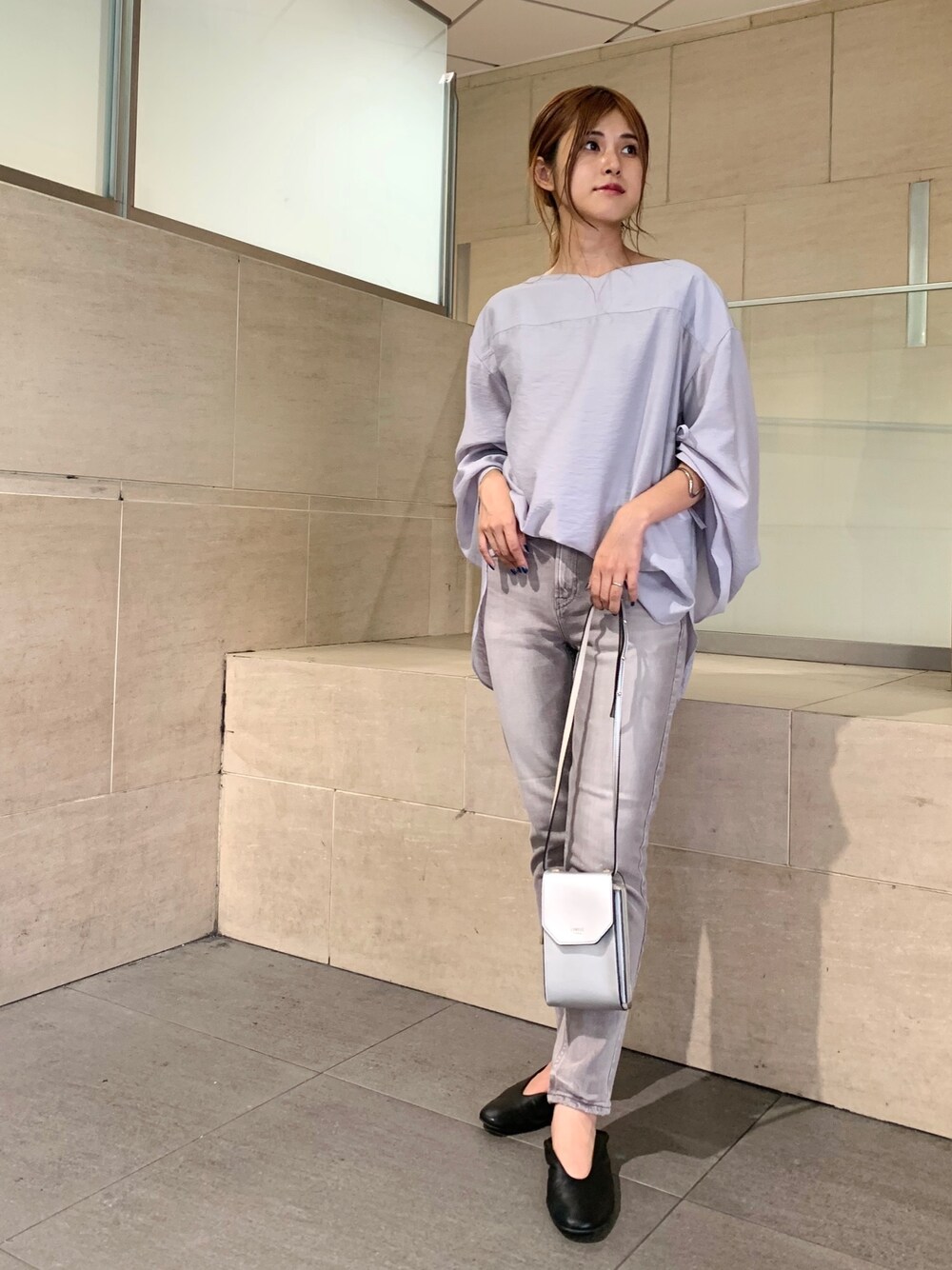 ブルー系のシャツ/ブラウス、ベージュ系のデニムパンツ、シルバー系のボディバッグ/ウエストポーチを着用したレディースの秋コーディネートの1枚目の写真