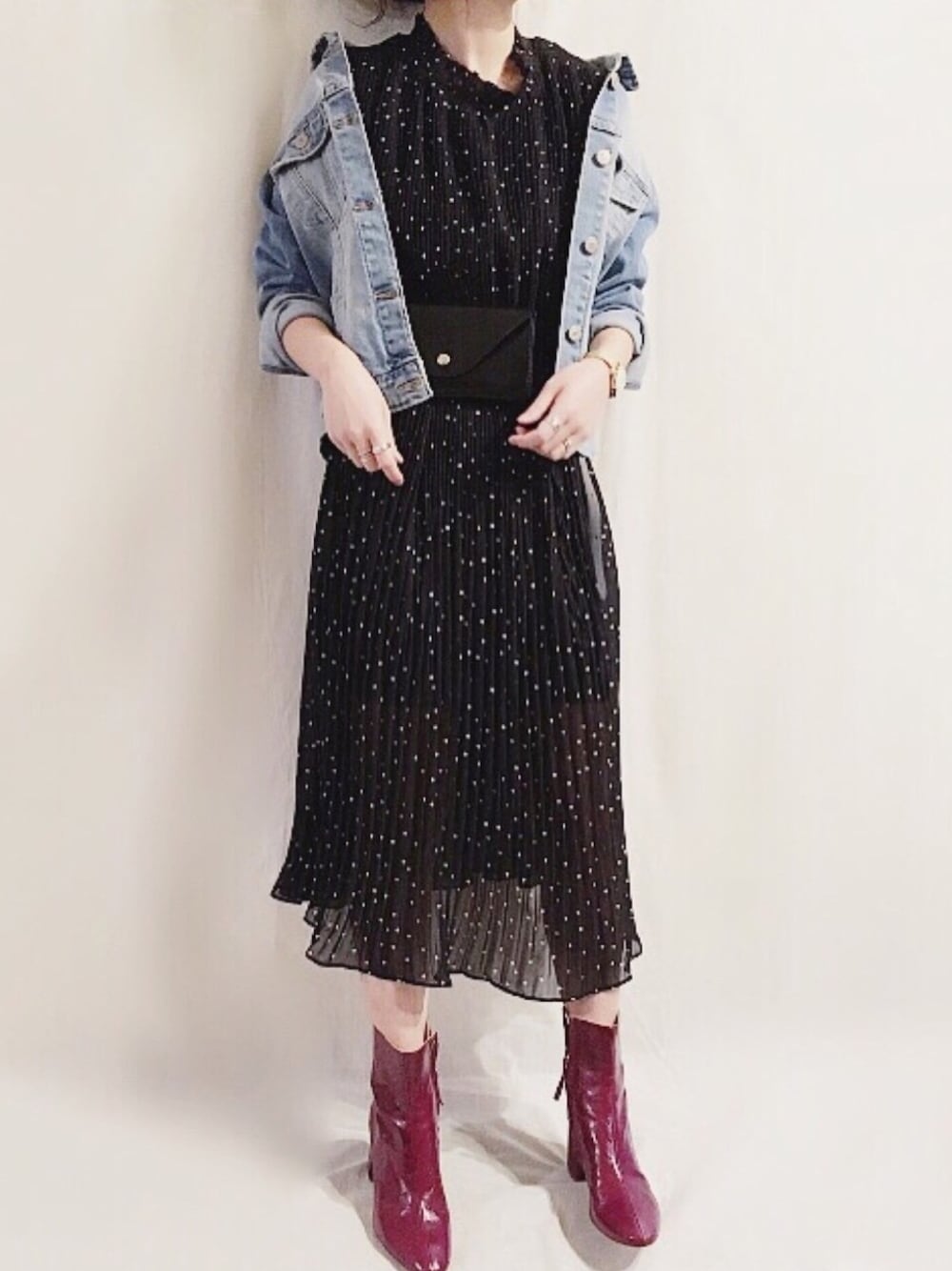 ブラック系のワンピース、ブラック系のボディバッグ/ウエストポーチ、レッド系のブーツを着用したレディースの春コーディネートの1枚目の写真