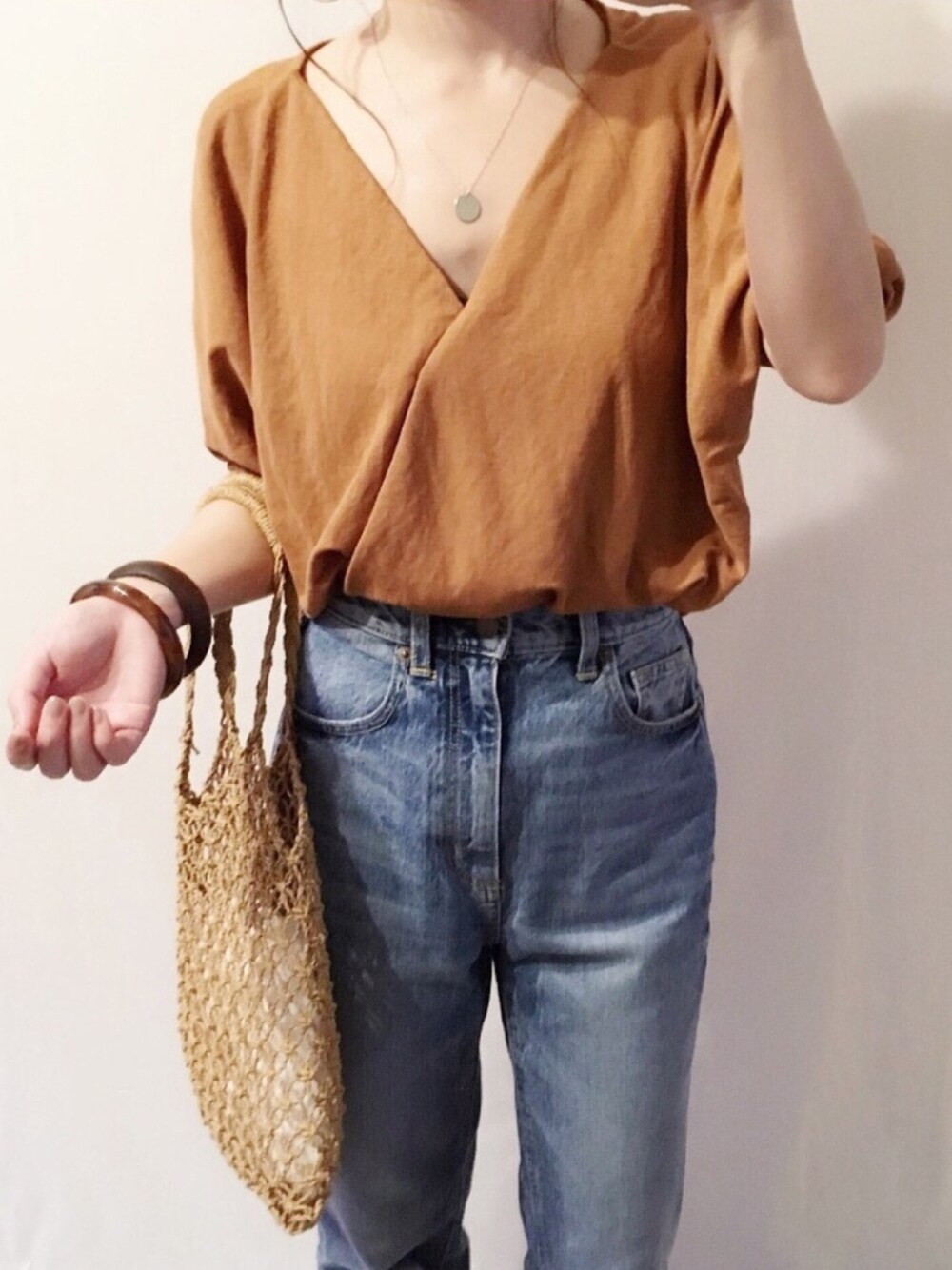 ブラウン系のシャツ/ブラウス、ブルー系のデニムパンツ、ベージュ系のトートバッグを着用したレディースの夏コーディネートの1枚目の写真