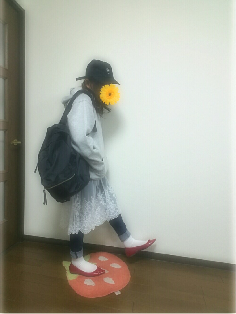 ブラック系のバックパック/リュック、ブルー系のデニムパンツ、レッド系のバレエシューズを着用したレディースの冬コーディネートの1枚目の写真