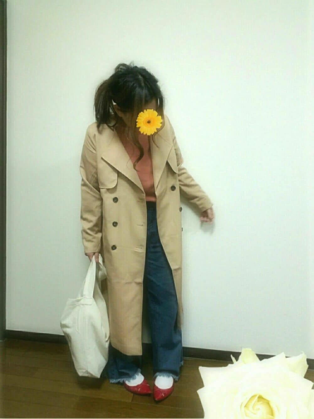 ベージュ系のトレンチコート、ピンク系のTシャツ/カットソー、ブルー系のデニムパンツを着用したレディースの冬コーディネートの1枚目の写真