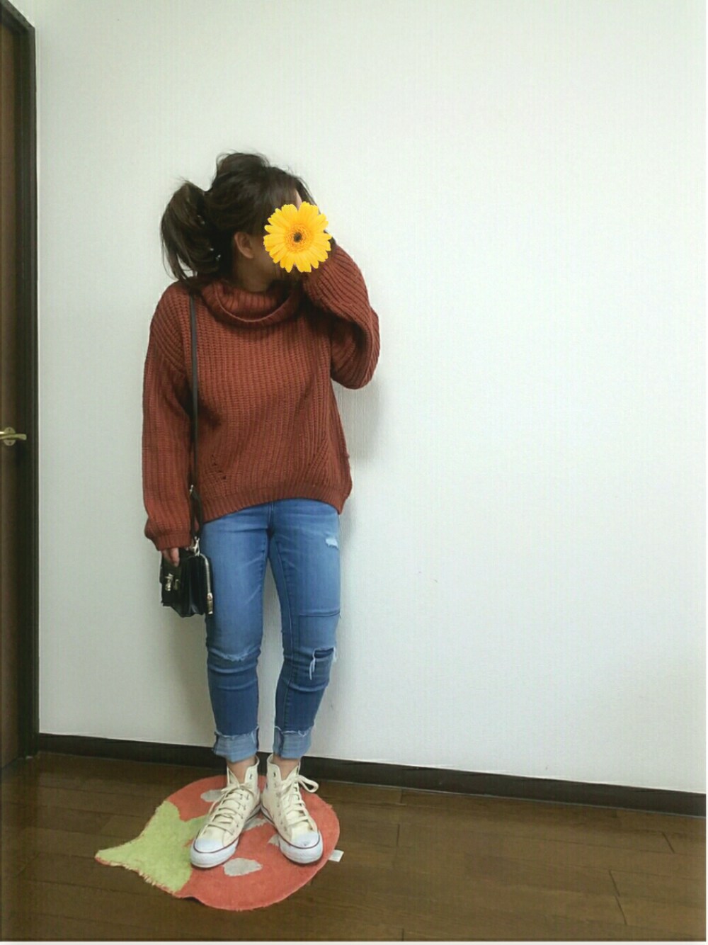 ブルー系のデニムパンツ、ホワイト系のスニーカー、ブラウン系のニット/セーターを着用したレディースの春コーディネートの1枚目の写真