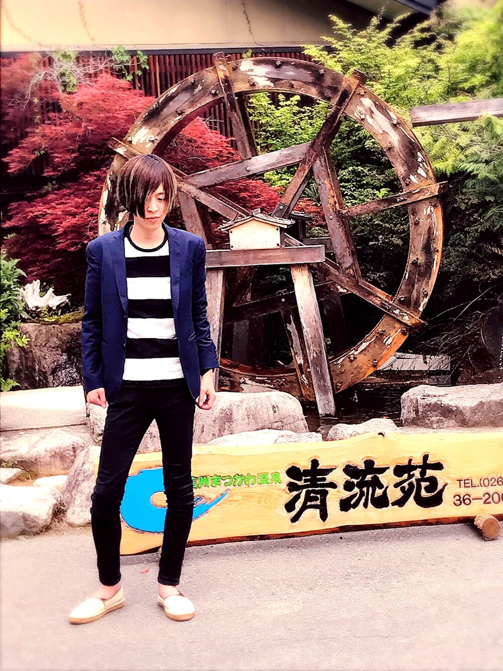 ブルー系のテーラードジャケット、ブラック系のチノパンツを着用したメンズの春コーディネートの1枚目の写真