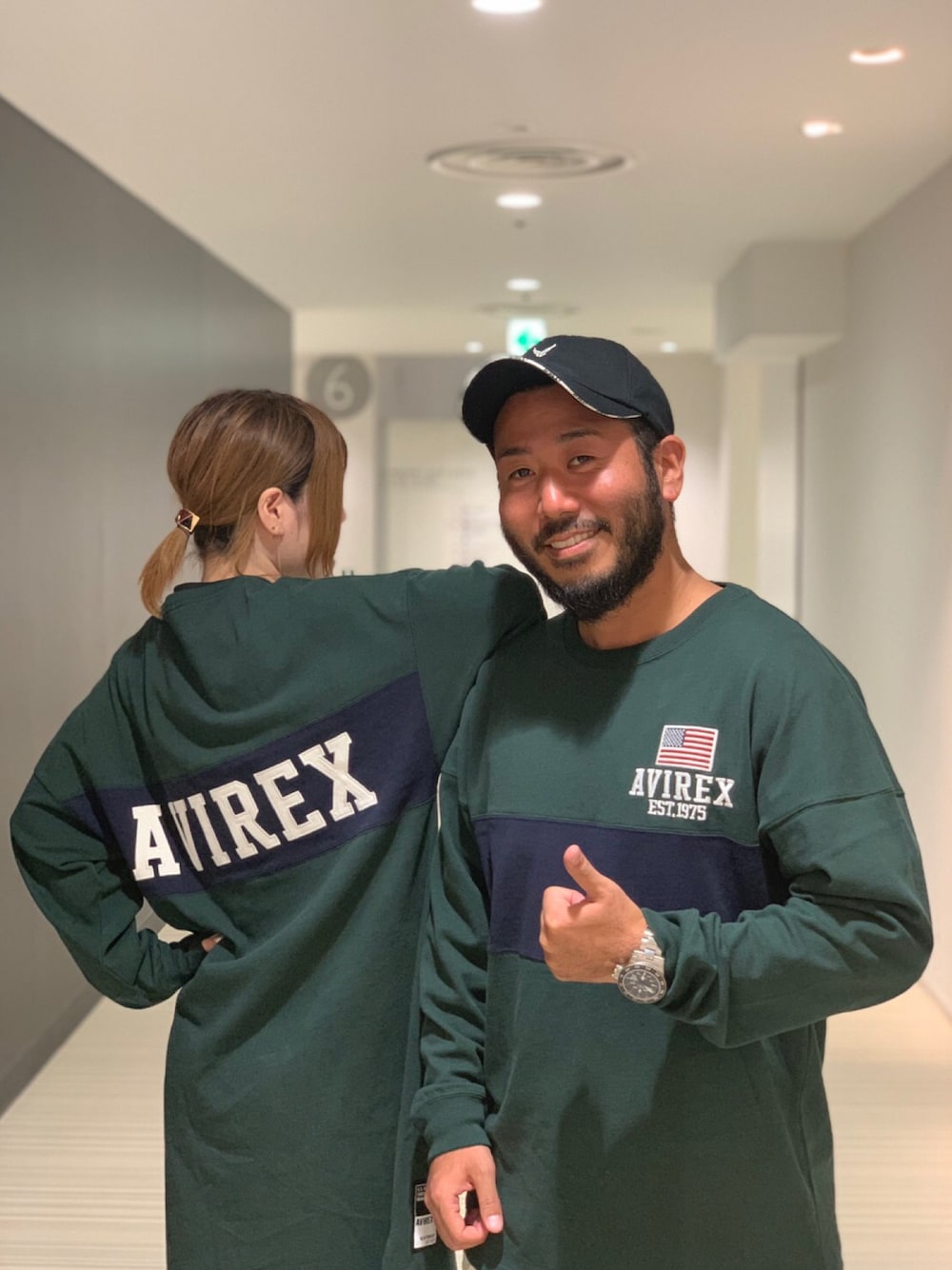「ロゴT、キャップ、AVIREX、静岡、ロゴスウェット、スポーツ、おそろいコーデ、カジュアルコーデ、ラガーシャツ、秋のカフェオレコーデ」｜「AVIREXのヴァーシティー ラガー クルーネック Tシャツ/ LS VARSITY RUGGER CREW NECK T-SHIRT（ポロシャツ、グリーン系）」を使った、Yoshi Yamaさん（メンズ・174cm）の秋コーディネートの1枚目の写真