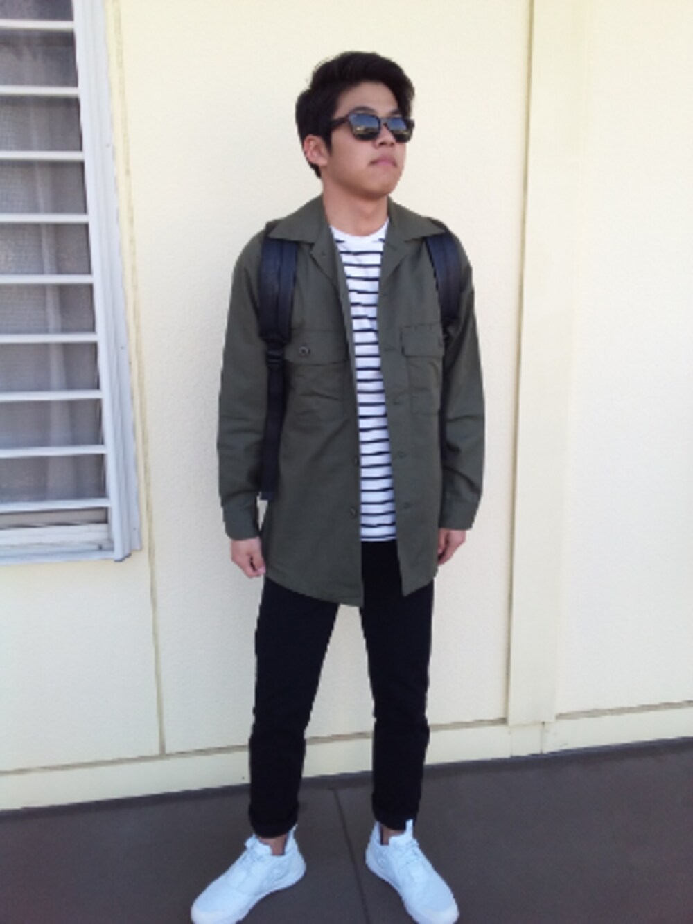 ホワイト系のスニーカー、ブラック系のバックパック/リュック、ブラック系のアナログ腕時計を着用したメンズの冬コーディネートの1枚目の写真