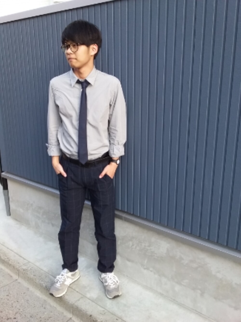 グレー系のスニーカー、ブラック系のバックパック/リュック、ブラック系のアナログ腕時計を着用したメンズの春コーディネートの1枚目の写真