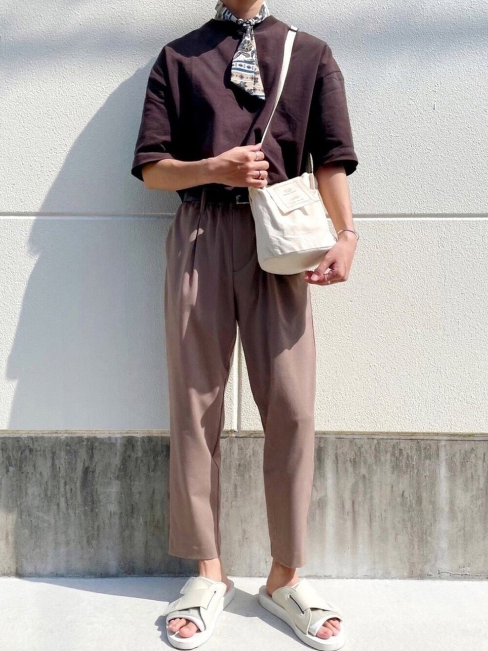 ブラウン系のTシャツ/カットソー、ベージュ系のショルダーバッグ、ベージュ系のその他パンツを着用したメンズの春コーディネートの1枚目の写真