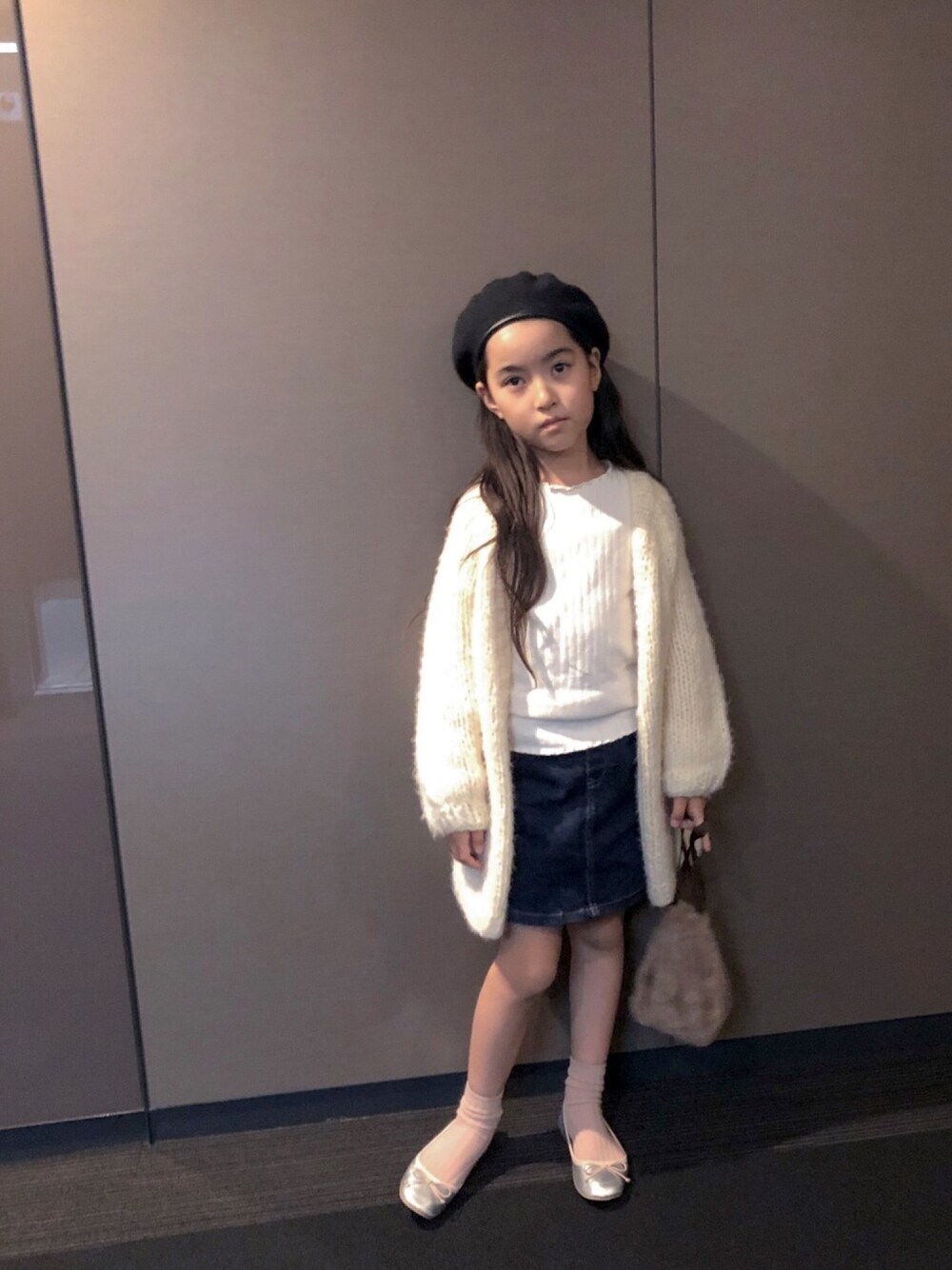 ホワイト系のカーディガン/ボレロ、ベージュ系のTシャツ/カットソー、シルバー系のバレエシューズを着用したキッズの秋コーディネートの1枚目の写真