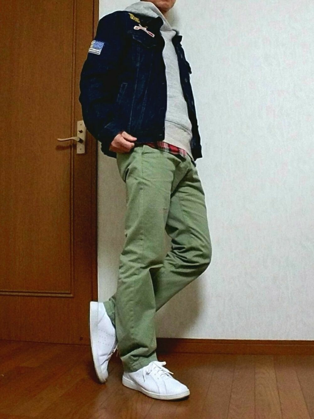 グレー系のパーカー、グリーン系のチノパンツ、ブルー系のデニムジャケットを着用したメンズの冬コーディネートの1枚目の写真