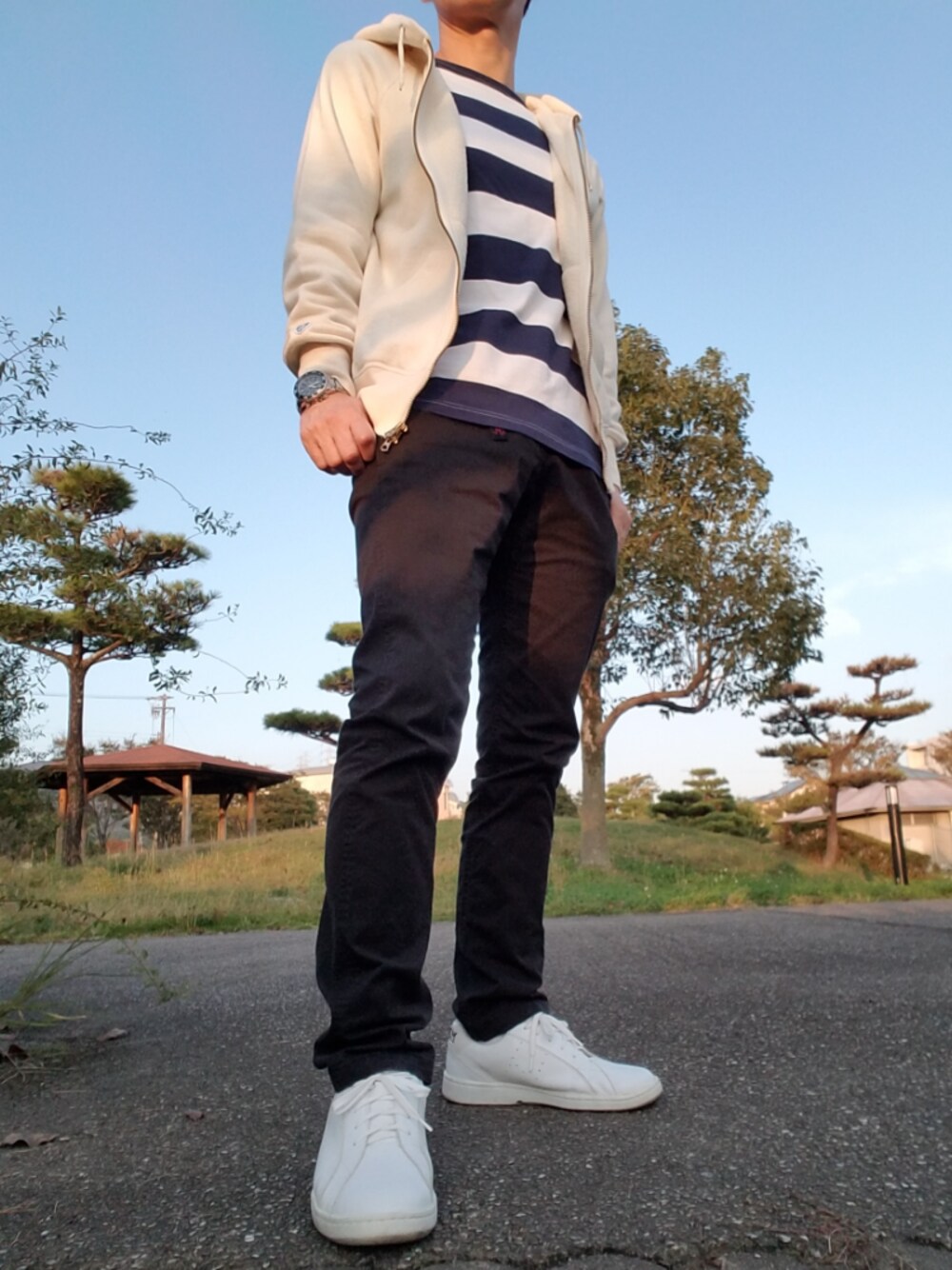 ブラック系のその他パンツ、ホワイト系のスニーカー、ベージュ系のパーカーを着用したメンズの秋コーディネートの1枚目の写真