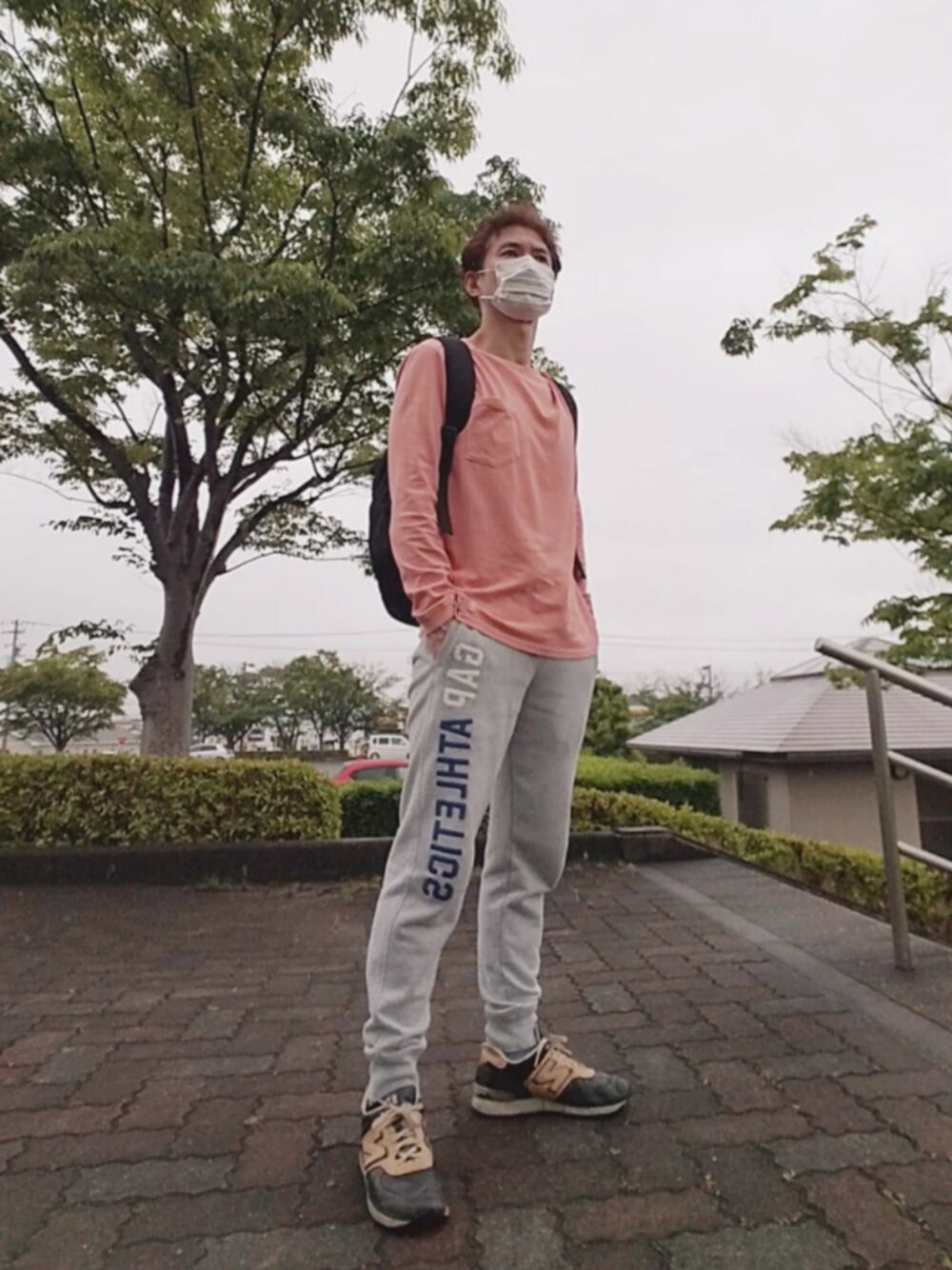 ブラック系のスニーカー、グレー系のスウェットパンツ、ピンク系のTシャツ/カットソーを着用したメンズの春コーディネートの1枚目の写真