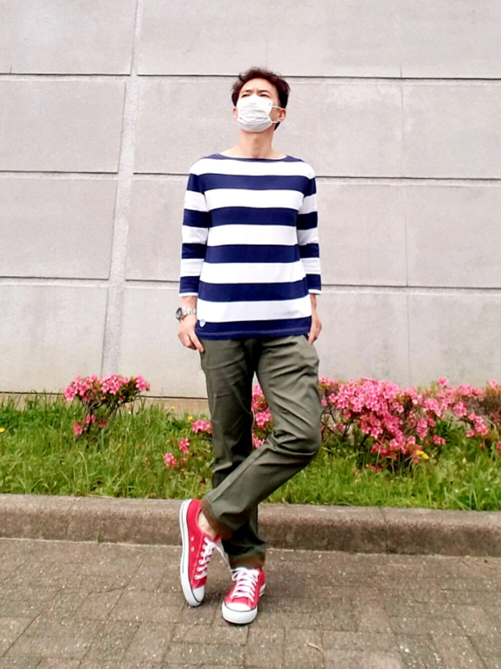 レッド系のスニーカー、ブルー系のTシャツ/カットソー、グリーン系のカーゴパンツを着用したメンズの春コーディネートの1枚目の写真