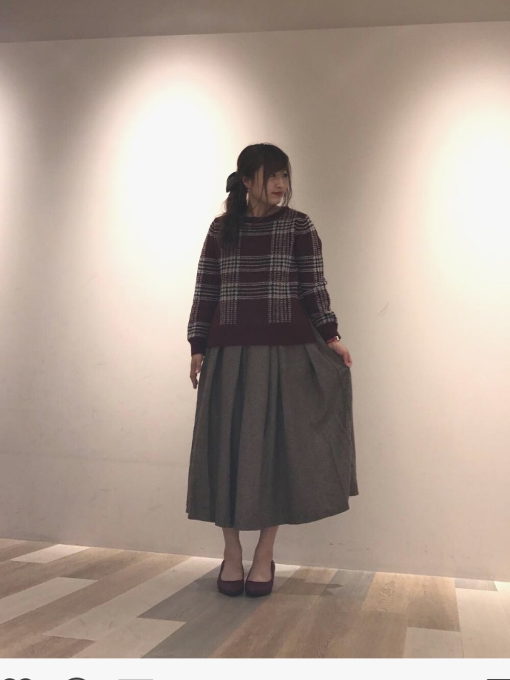 レッド系のニット/セーター、ベージュ系のスカートを着用したレディースの秋コーディネートの1枚目の写真