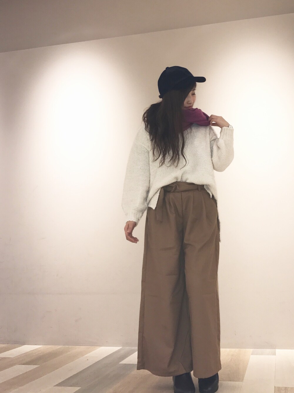 イエロー系のその他パンツ、ホワイト系のニット/セーター、ピンク系のマフラーを着用したレディースの冬コーディネートの1枚目の写真
