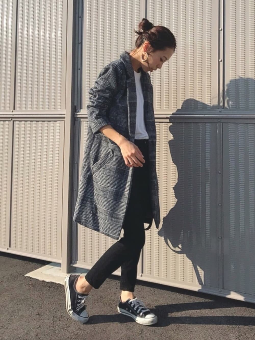 ブラック系のデニムパンツ、ブラック系のスニーカー、グレー系のジャケット/アウターを着用したレディースの秋コーディネートの1枚目の写真