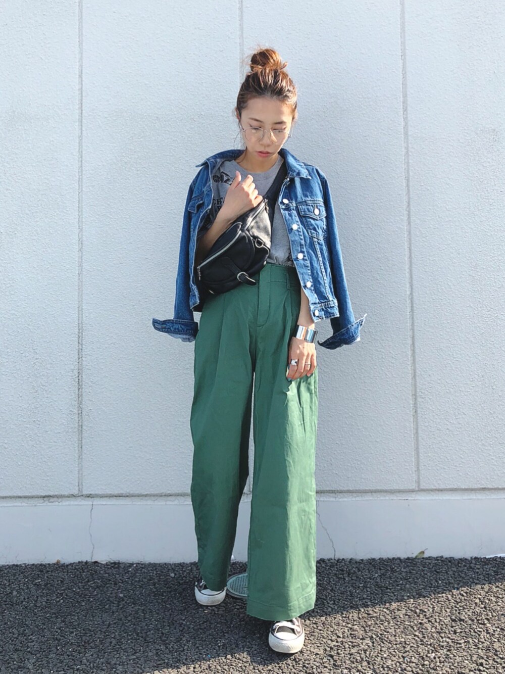 ブルー系のデニムジャケット、ブラック系のスニーカー、グリーン系のパンツを着用したレディースの春コーディネートの1枚目の写真
