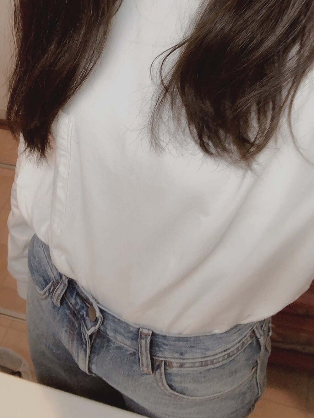 ブルー系のデニムパンツ、ホワイト系のTシャツ/カットソー、ブラック系のスニーカーを着用したレディースの冬コーディネートの1枚目の写真