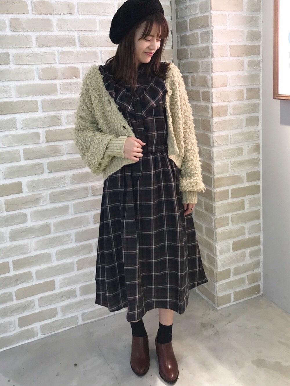 ブルー系のワンピース、ベージュ系のカーディガン/ボレロ、ブラウン系のブーティを着用したレディースの秋コーディネートの1枚目の写真