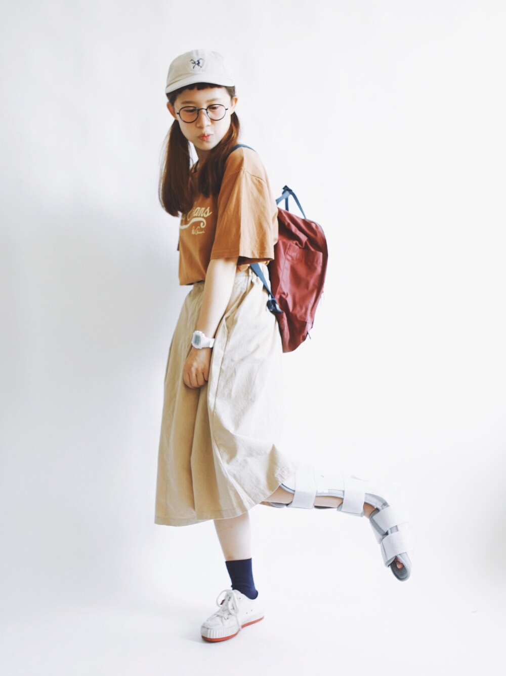 ブラウン系のTシャツ/カットソー、レッド系のバックパック/リュック、ベージュ系のスカートを着用したレディースの夏コーディネートの1枚目の写真