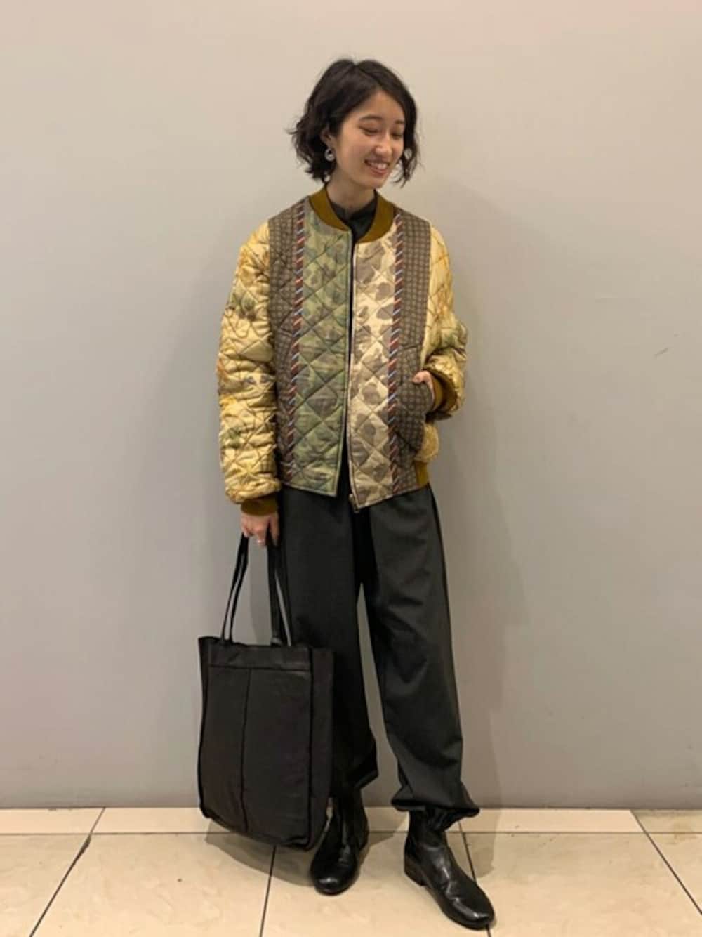 イエロー系のブルゾン、グレー系のつなぎ/オールインワン、ブラック系のトートバッグを着用したレディースの秋コーディネートの1枚目の写真