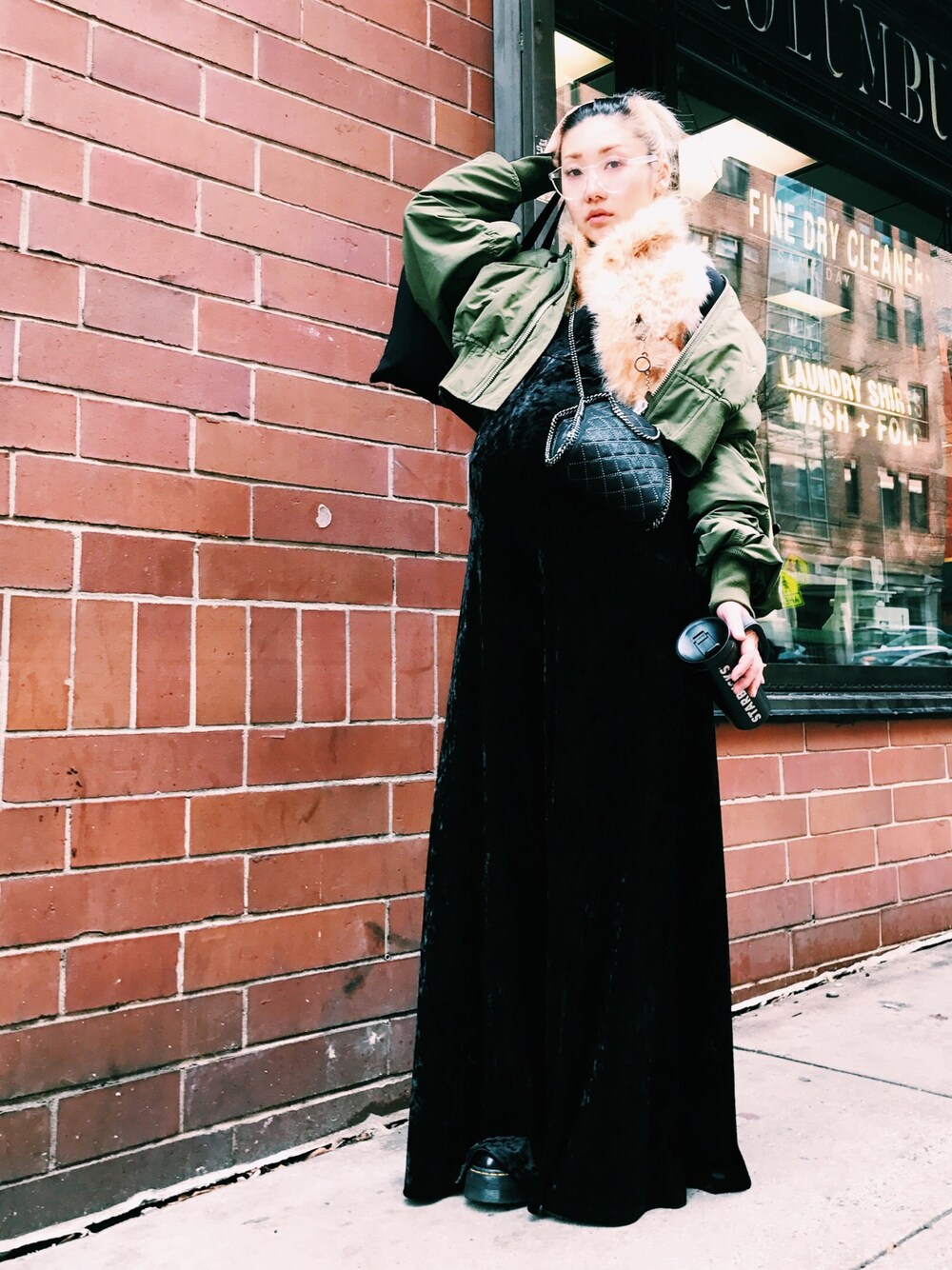 ブラック系のブーツ、グリーン系のMA-1、ブラック系のショルダーバッグを着用したレディースの冬コーディネートの1枚目の写真