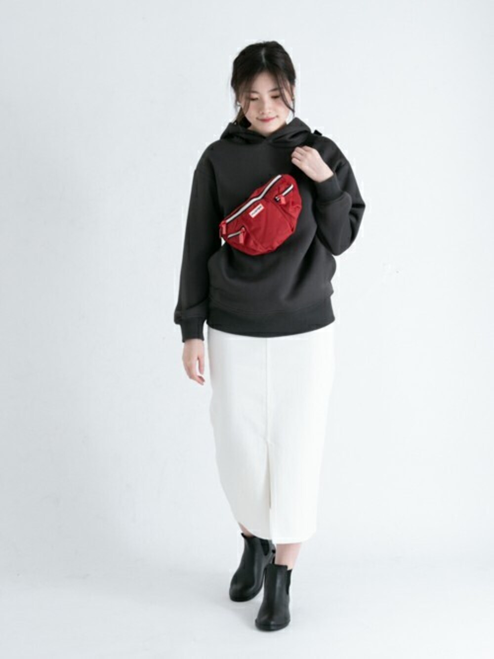 レッド系のボディバッグ/ウエストポーチ、グレー系のTシャツ/カットソー、ブラック系のブーツを着用したレディースの冬コーディネートの1枚目の写真