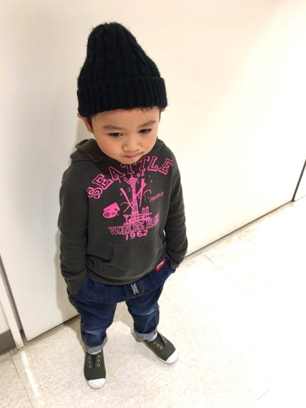 グレー系のパーカー、ブルー系のデニムパンツ、グリーン系のスニーカーを着用したキッズの冬コーディネートの1枚目の写真