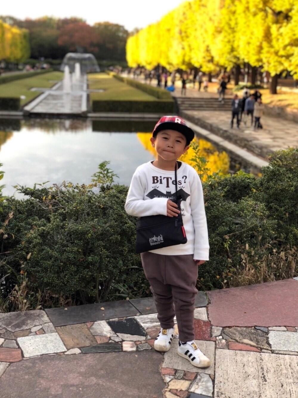 ホワイト系のスウェット、ブラック系のショルダーバッグ、ブラウン系のその他パンツを着用したキッズの秋コーディネートの1枚目の写真