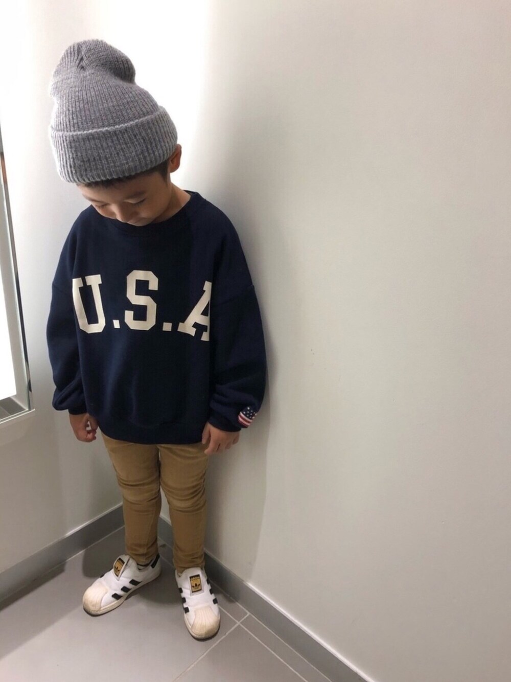 ブルー系のスウェット、ベージュ系のその他パンツ、ホワイト系のスニーカーを着用したキッズの秋コーディネートの1枚目の写真