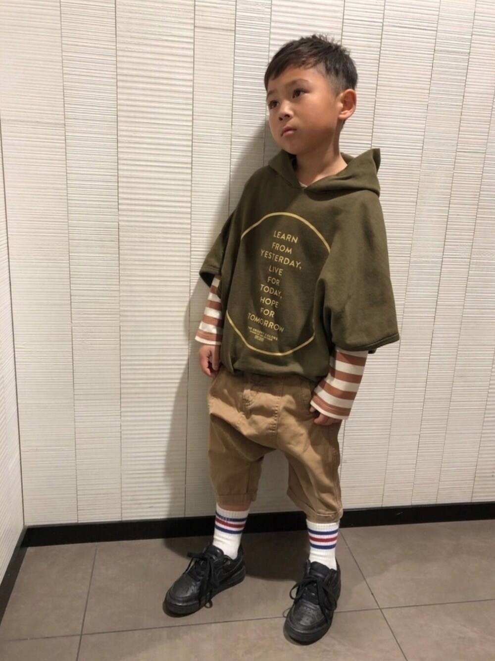 グリーン系のパーカー、ベージュ系のパンツ、ブラック系のスニーカーを着用したキッズの春コーディネートの1枚目の写真