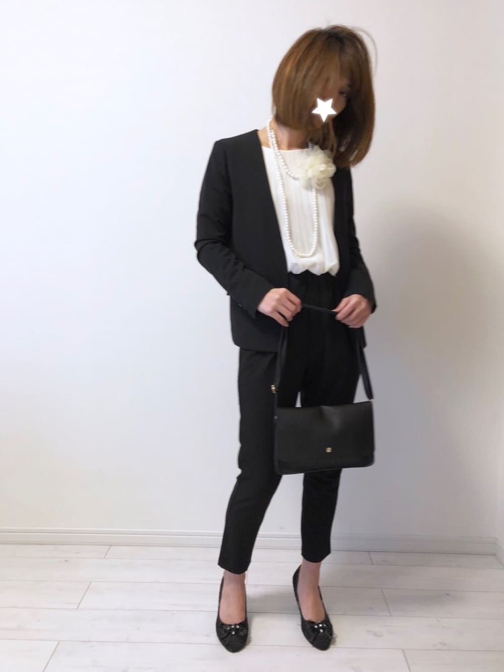 ブラック系のノーカラージャケット、ホワイト系のシャツ/ブラウス、ブラック系のパンツを着用したレディースの春コーディネートの1枚目の写真