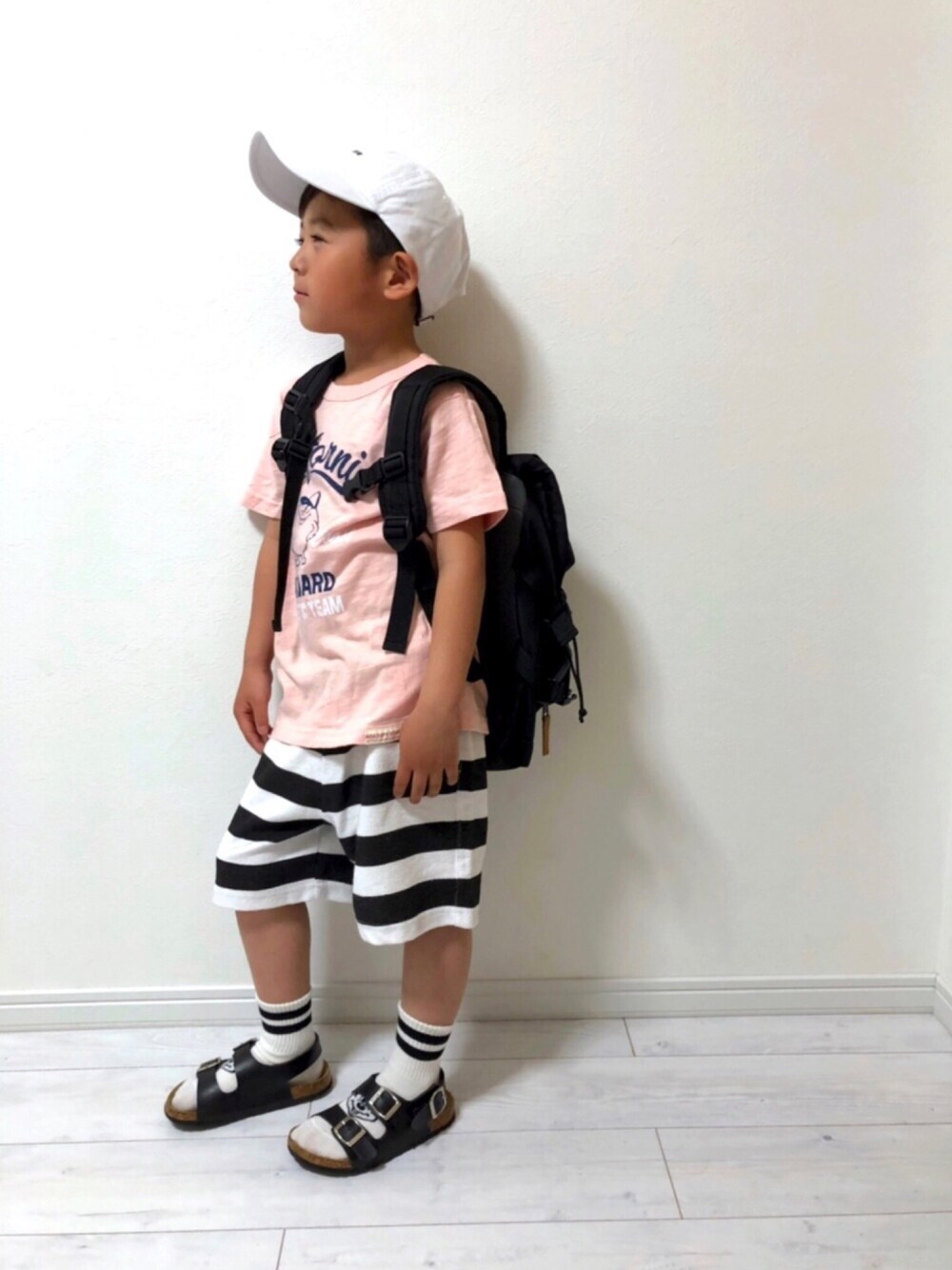 ピンク系のTシャツ/カットソー、ブラック系のバックパック/リュック、ホワイト系のその他パンツを着用したキッズの春コーディネートの1枚目の写真