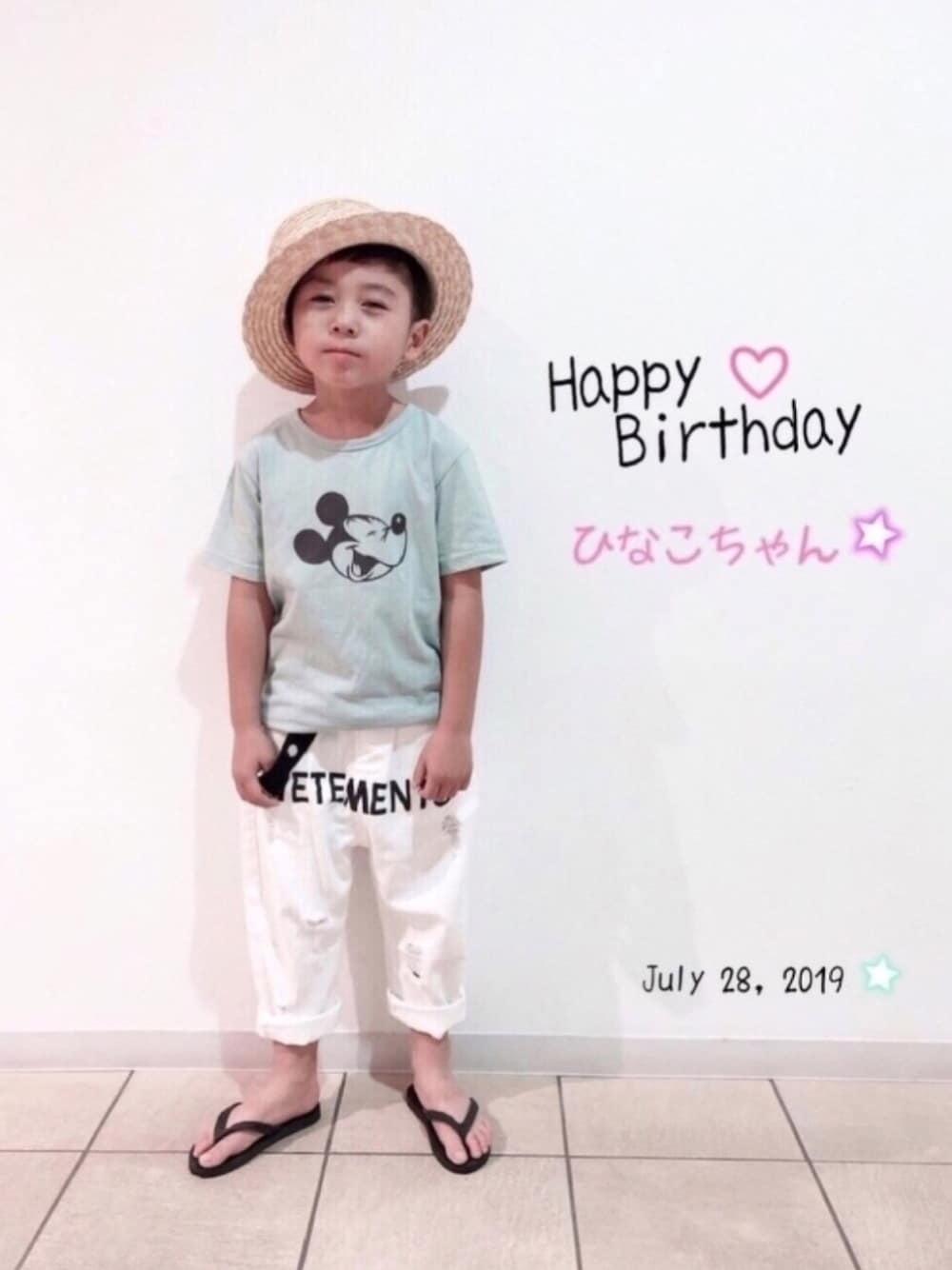 グリーン系のTシャツ/カットソー、ホワイト系のパンツ、ブラック系のサンダルを着用したキッズの夏コーディネートの1枚目の写真
