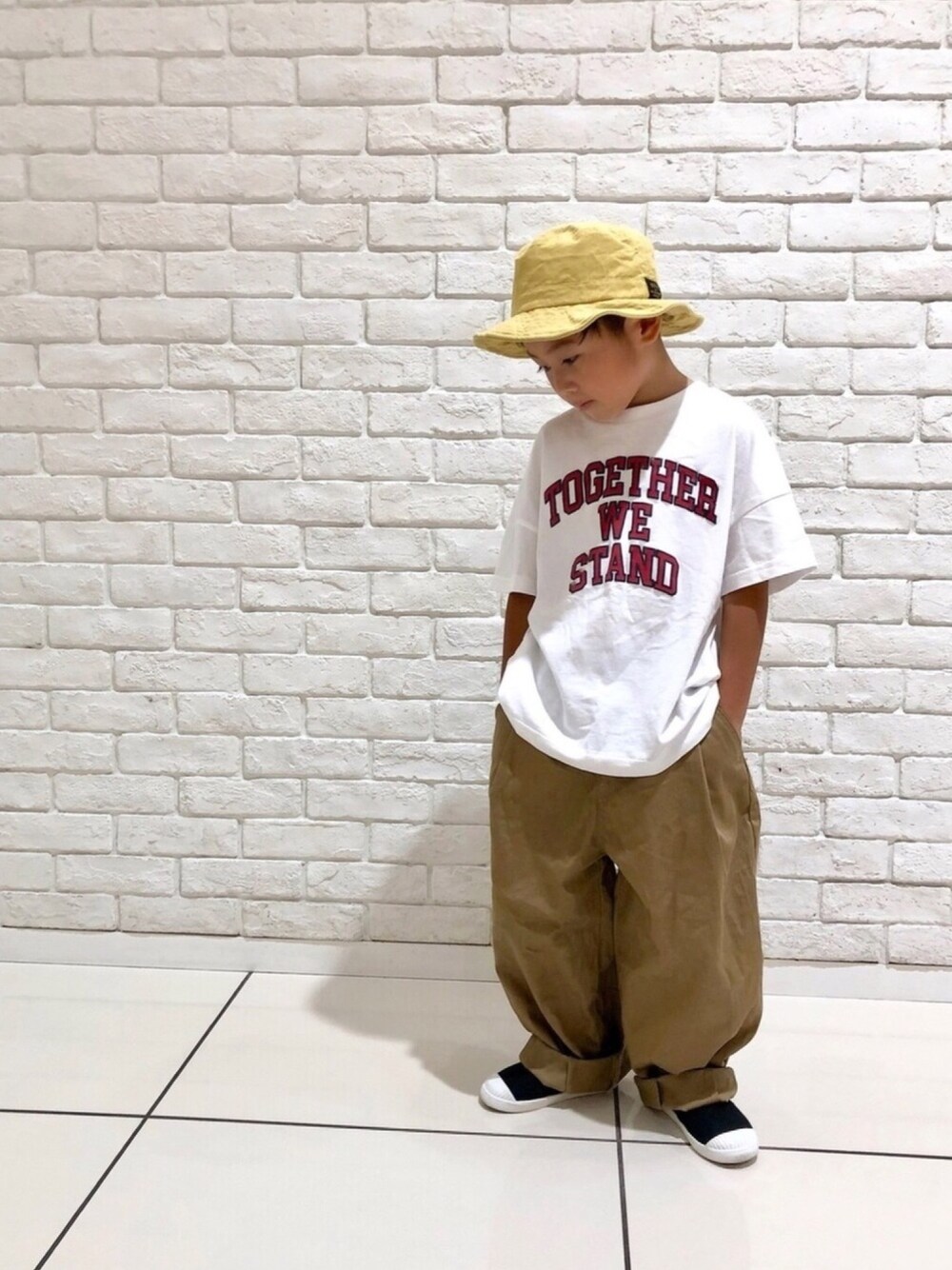 ホワイト系のTシャツ/カットソー、ベージュ系のその他パンツ、ブラック系のスリッポンを着用したキッズの秋コーディネートの1枚目の写真