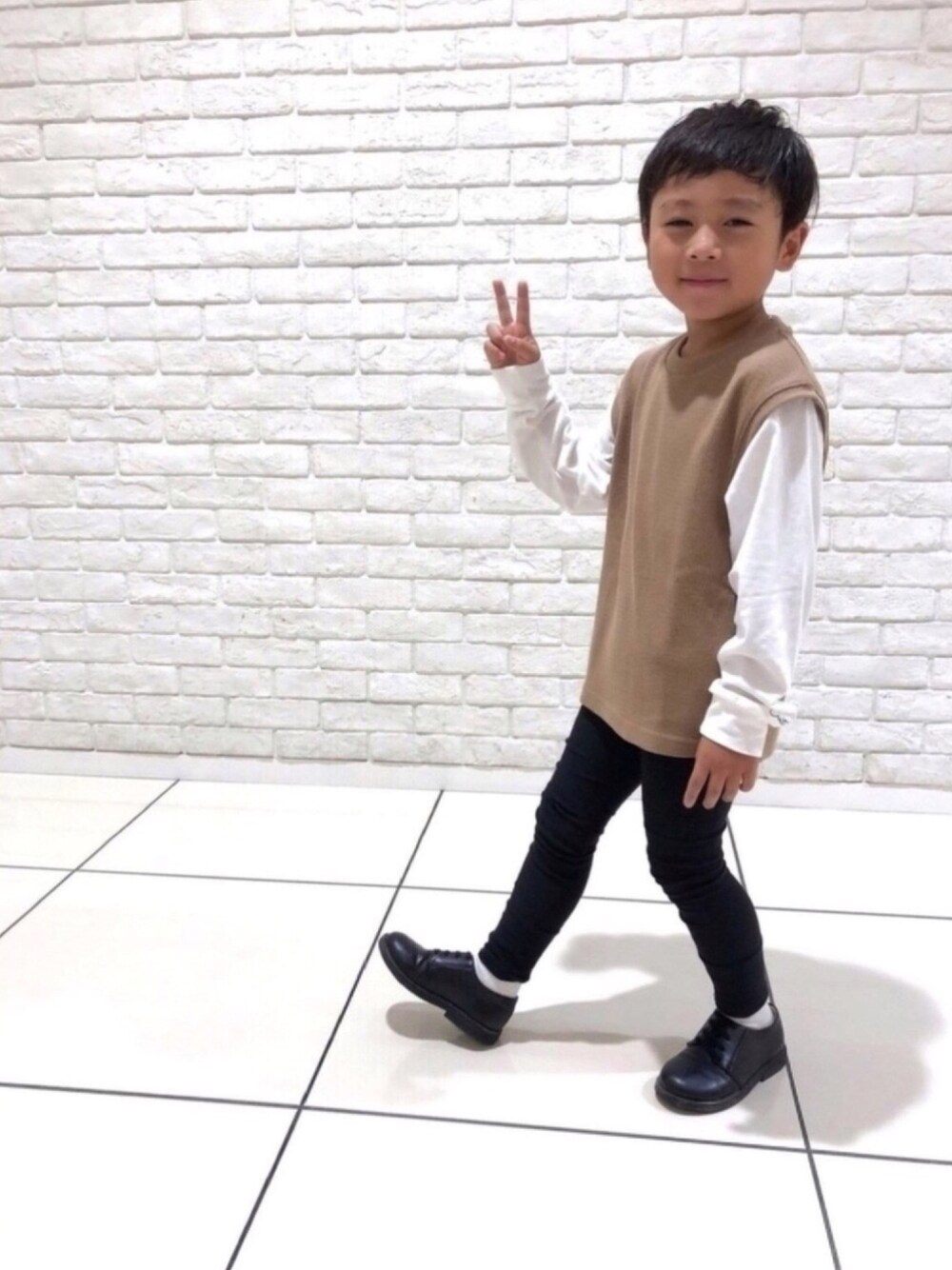 ベージュ系のTシャツ/カットソー、ブラック系のその他パンツ、ブラック系のドレスシューズを着用したキッズの秋コーディネートの1枚目の写真