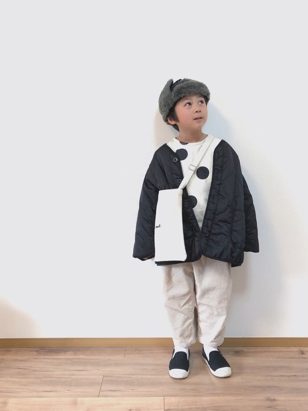 グレー系のブルゾン、ホワイト系のTシャツ/カットソー、ホワイト系のショルダーバッグを着用したキッズの冬コーディネートの1枚目の写真