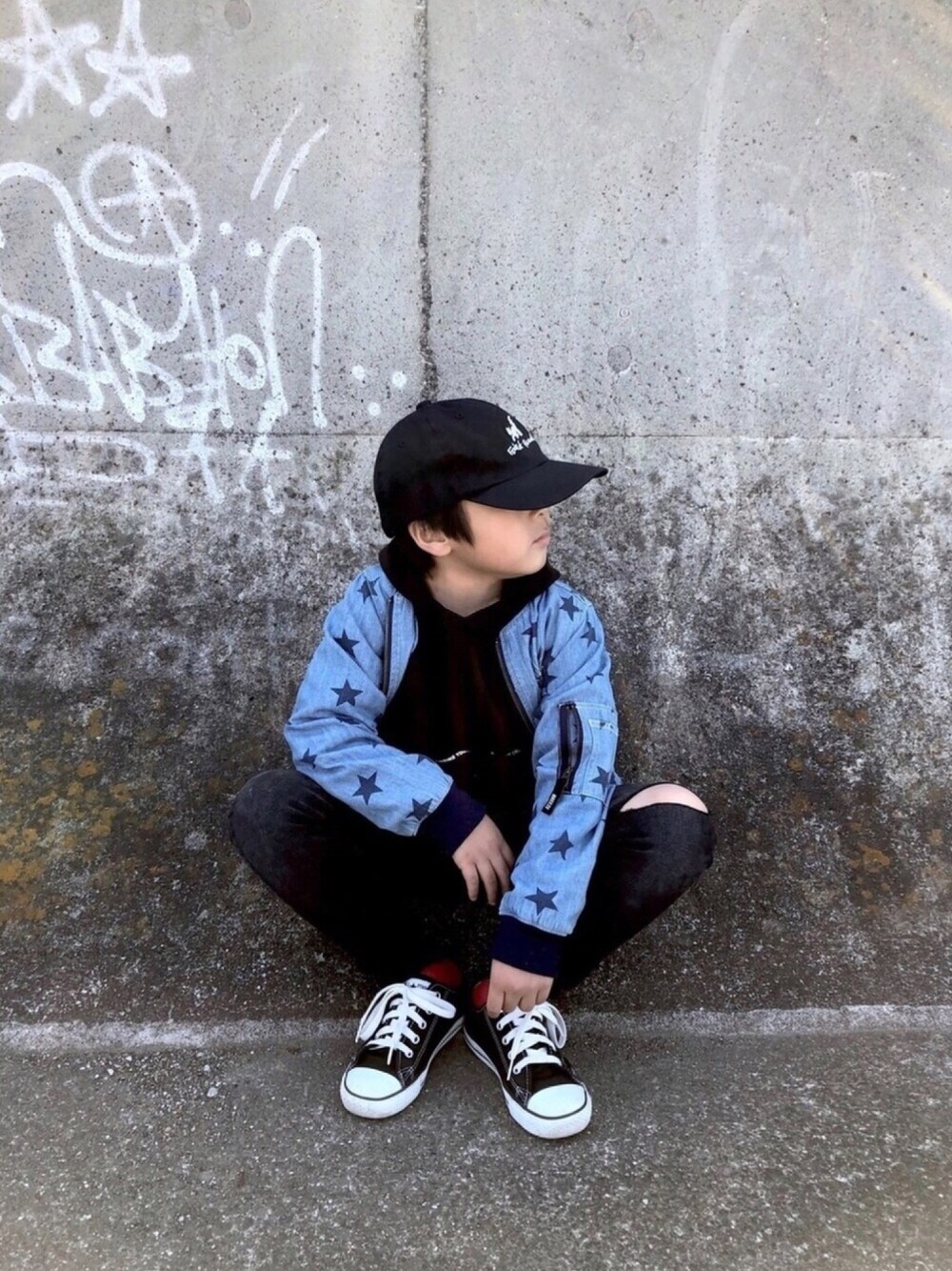 ブラック系のパーカー、ブルー系のMA-1、ブラック系のデニムパンツを着用したキッズの春コーディネートの1枚目の写真