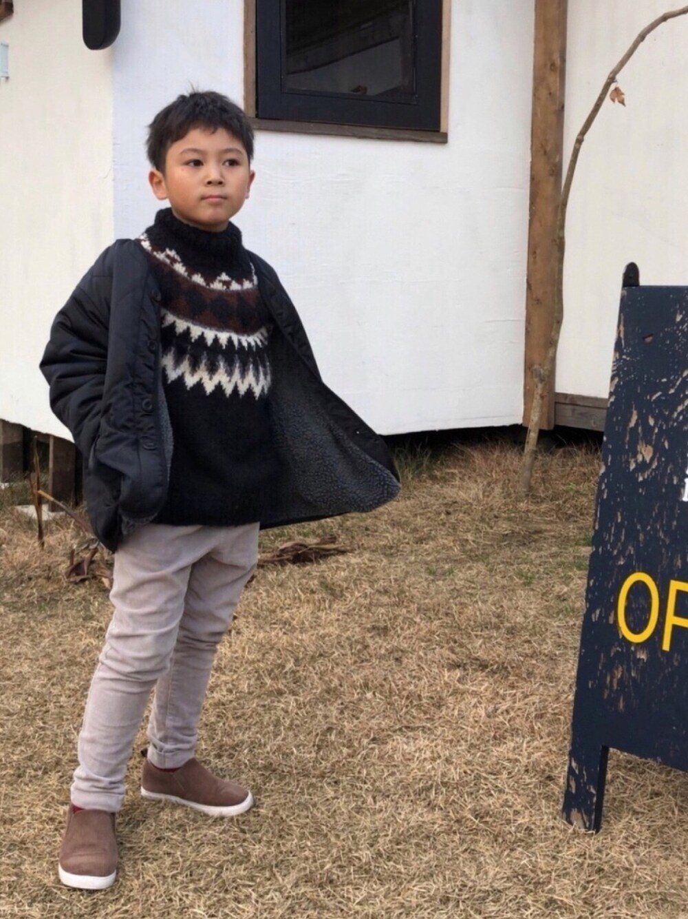 グレー系のブルゾン、ブラウン系のニット/セーター、グレー系のその他パンツを着用したキッズの冬コーディネートの1枚目の写真