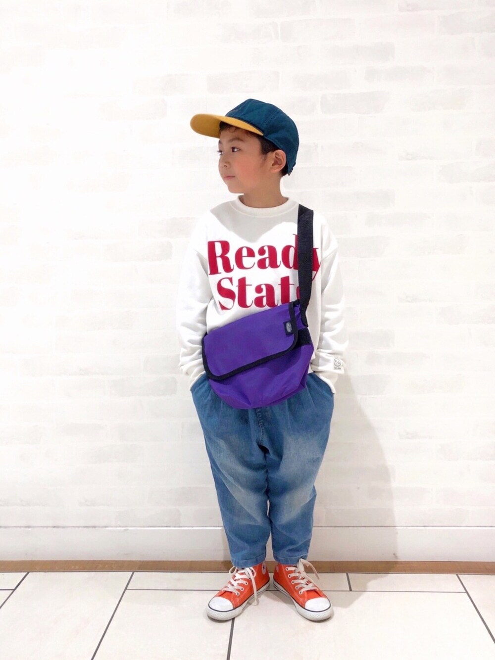 ホワイト系のスウェット、ブルー系のその他パンツ、オレンジ系のスニーカーを着用したキッズの春コーディネートの1枚目の写真