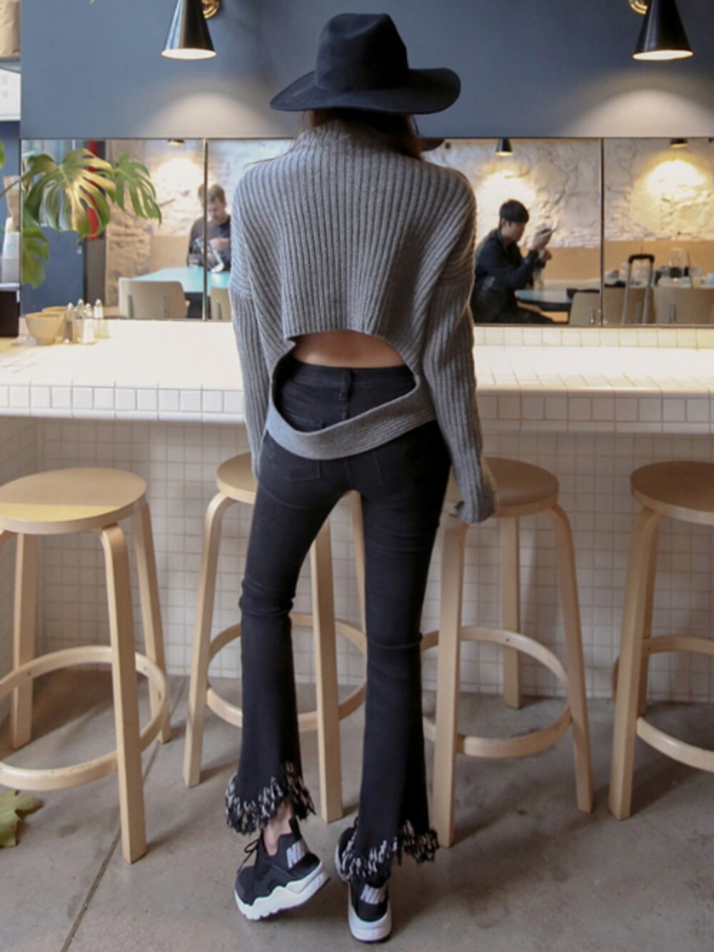 ブラック系のデニムパンツ、グレー系のニット/セーター、ブラック系のその他アウターを着用したレディースの冬コーディネートの1枚目の写真