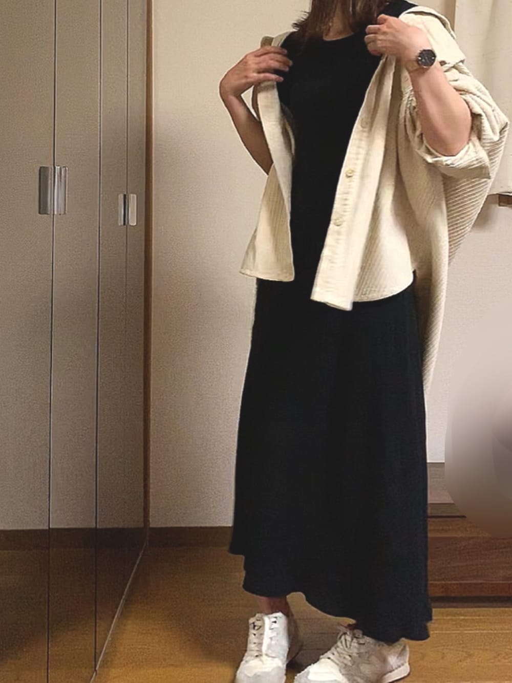 ブラック系のワンピース、ベージュ系のシャツ/ブラウス、ホワイト系のスニーカーを着用したレディースの春コーディネートの1枚目の写真