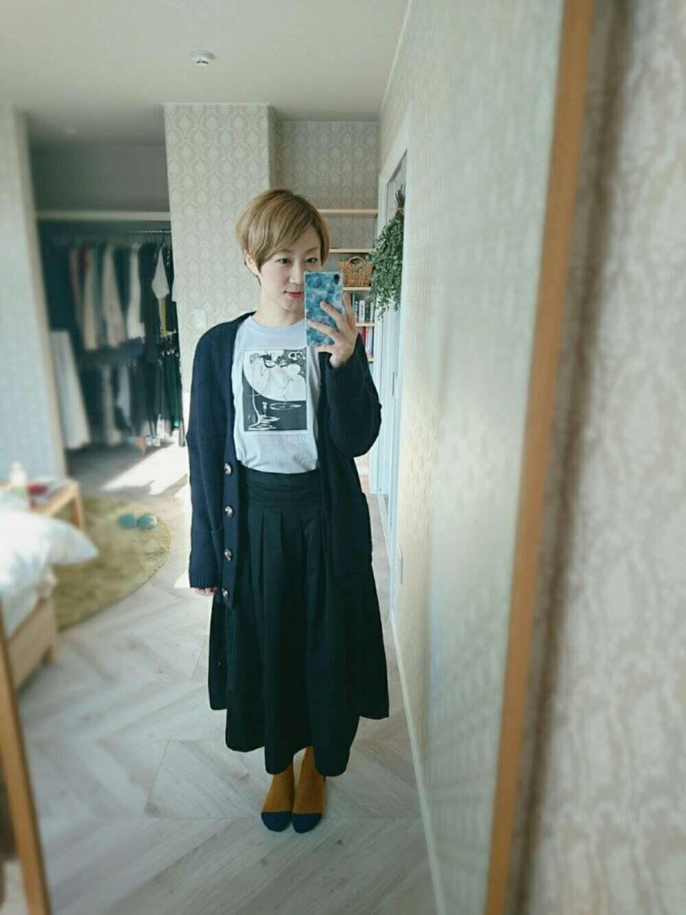 グレー系のTシャツ/カットソー、ブラック系のスカート、ブラック系のシューズを着用したレディースの秋コーディネートの1枚目の写真